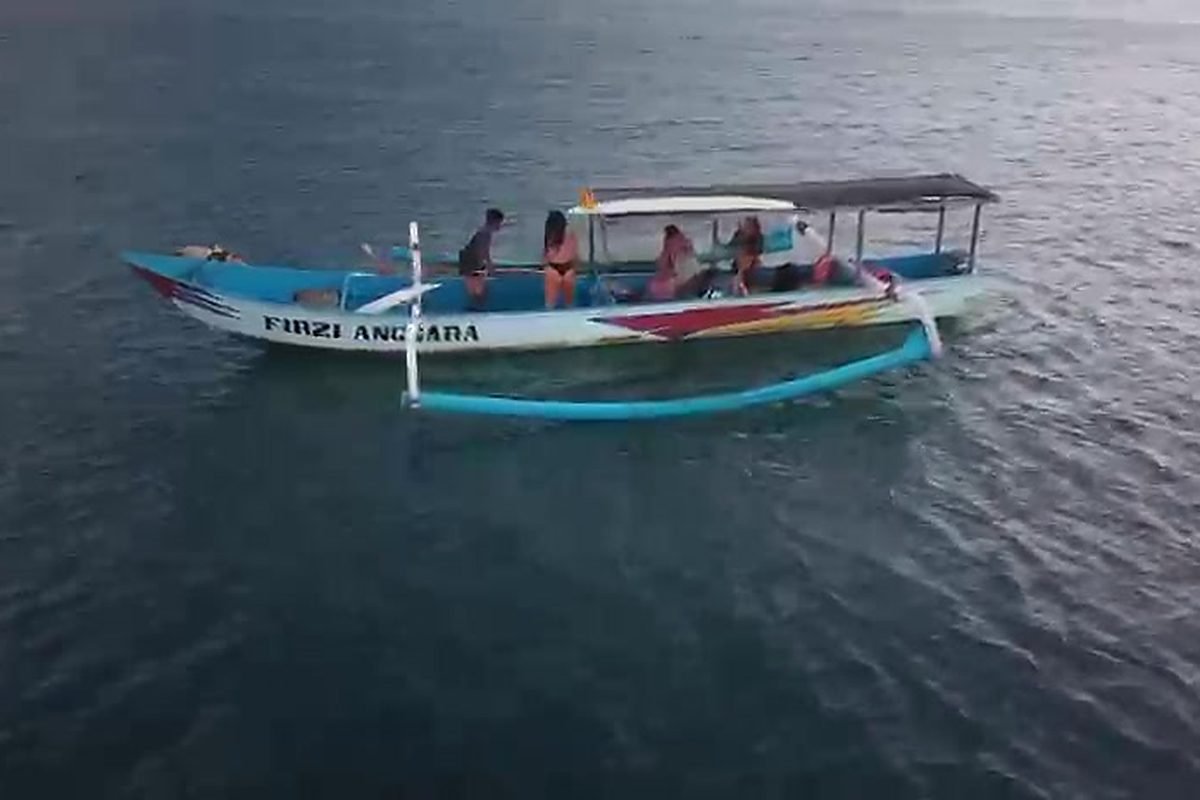 The boat sitting on the shoulder while the surfers trade waves