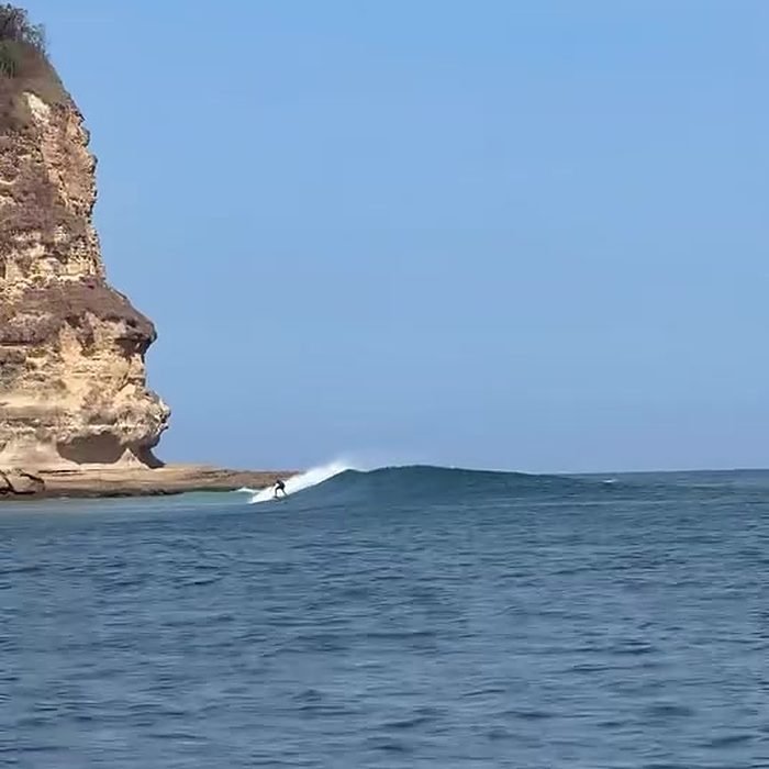 A wave peeling below the cliffs at Ekas
