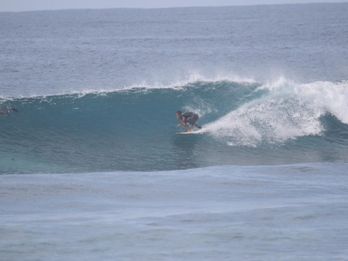 A surfer setting his line on a clean right-hander off the east coast of Lombok